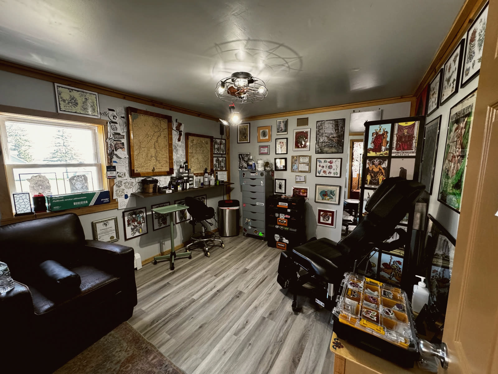 The private tattoo station with chair, maps and tarot prints